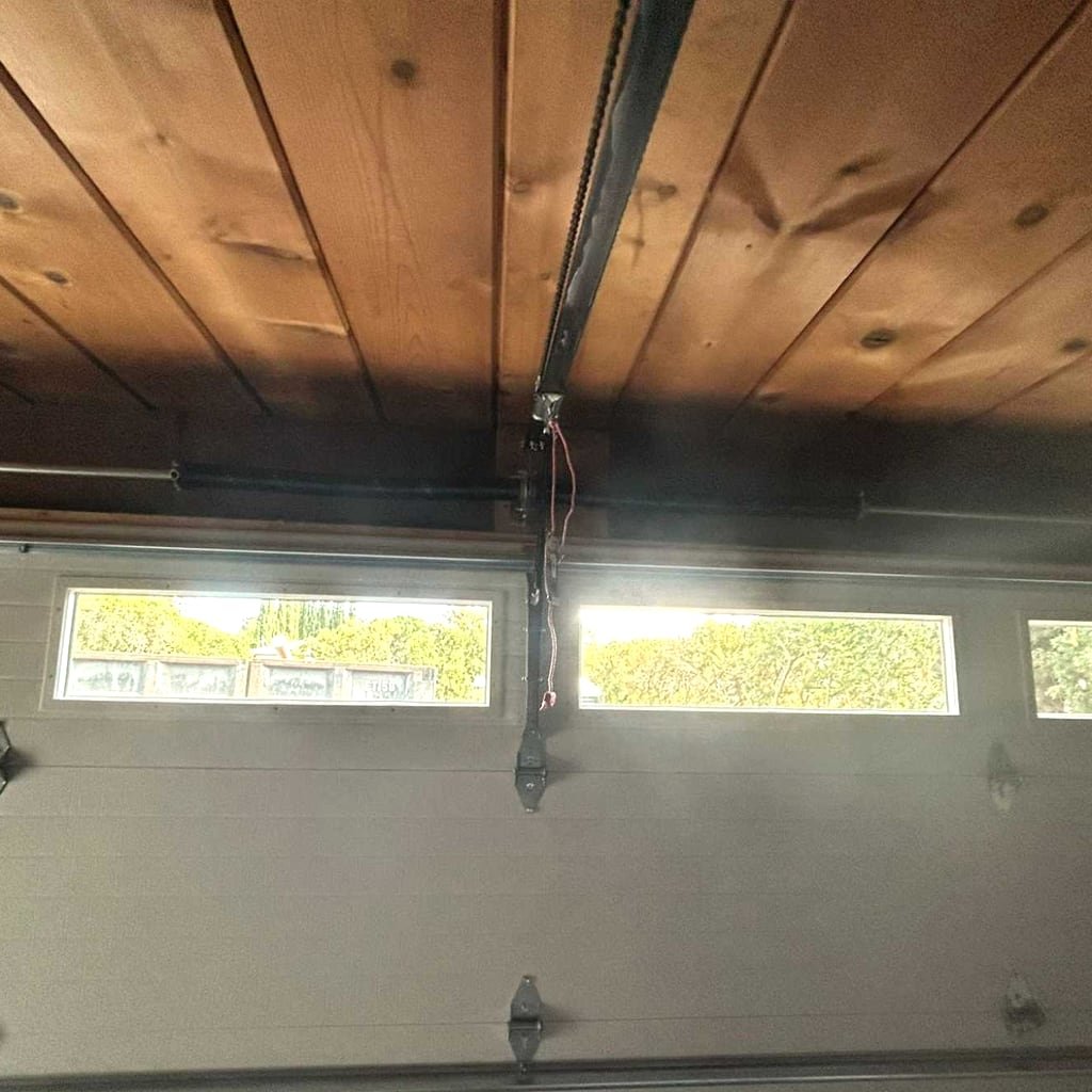 Opener rail and chain running across a timber garage ceiling